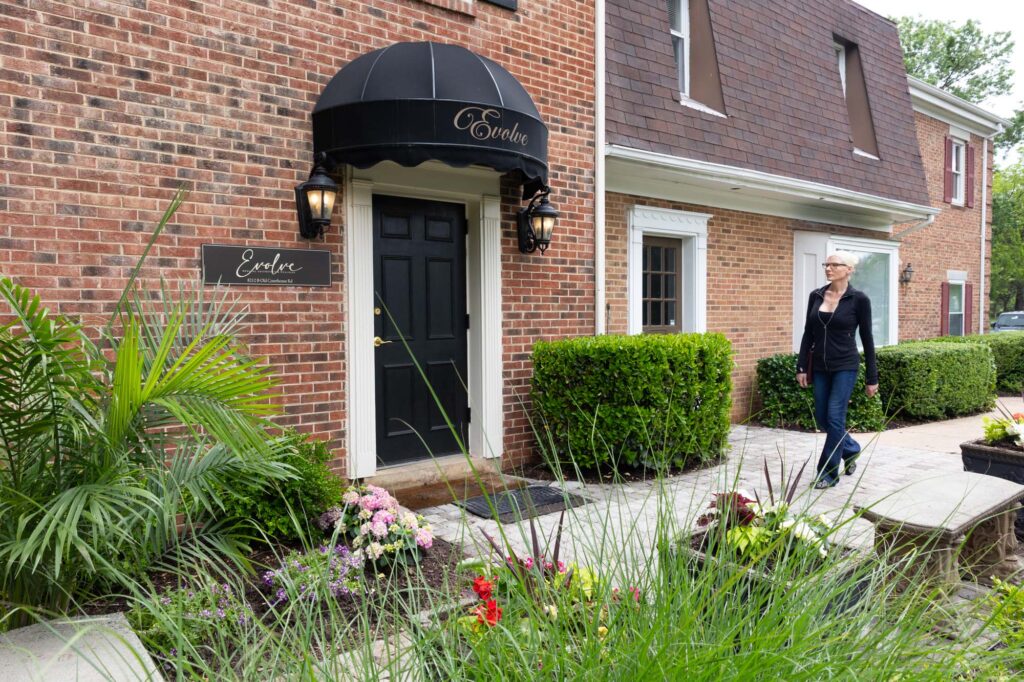 Woman walks towards the entrance of Evolve Medical Aesthetics + Wellness, a med spa where patients can receive a treatment for laser for sun damage in Vienna.